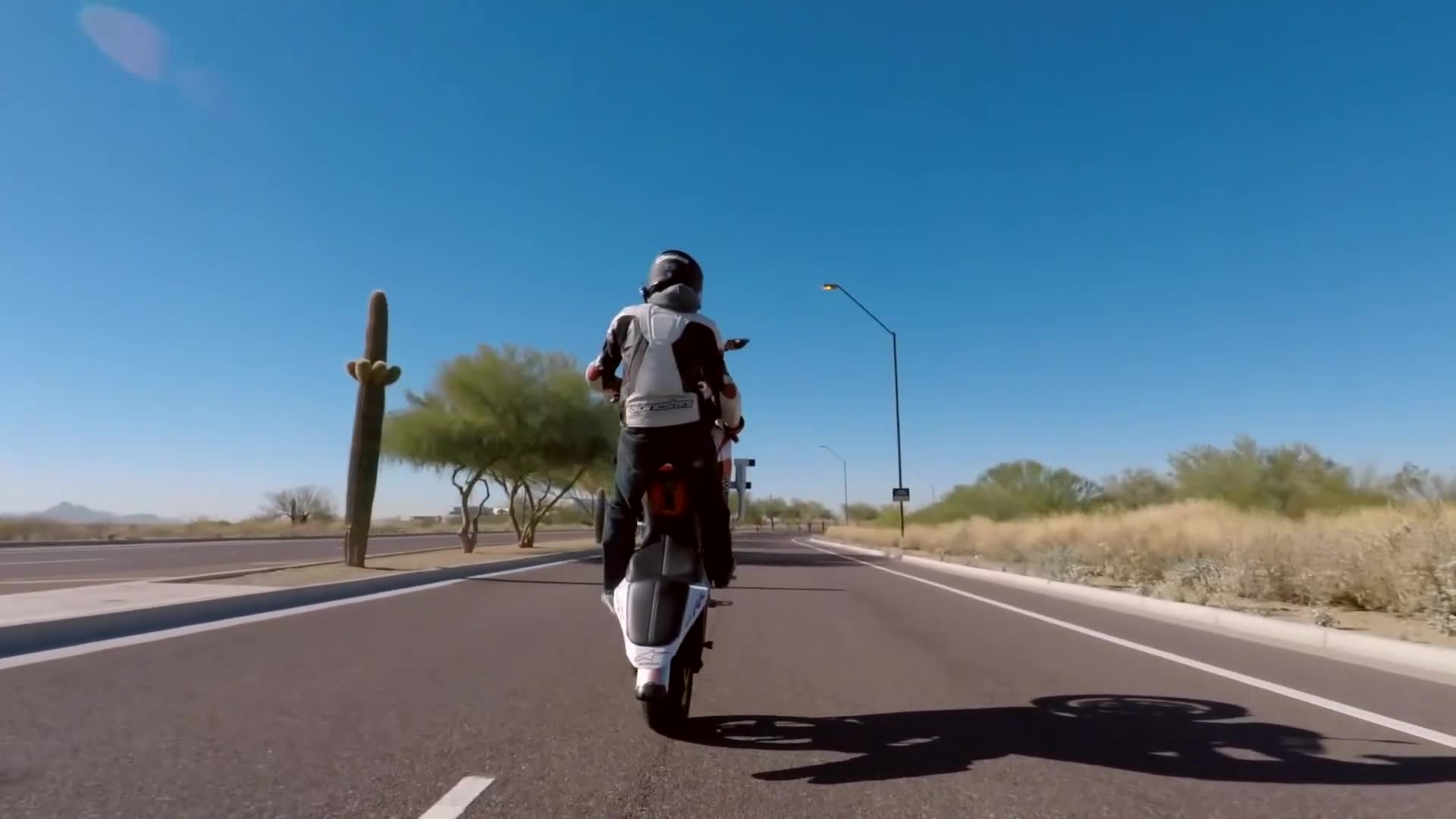 Attempting motorcycle stunts and riding inside concrete skateboard park