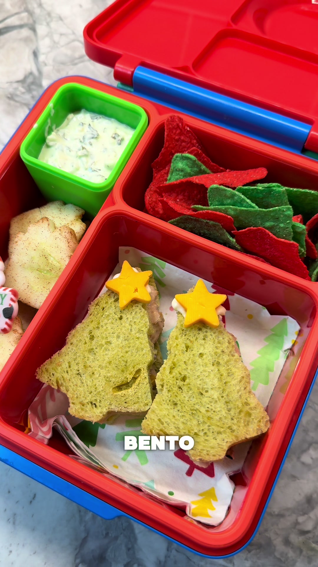 Holiday bento featuring tree-shaped tuna on green bread with creamy dip