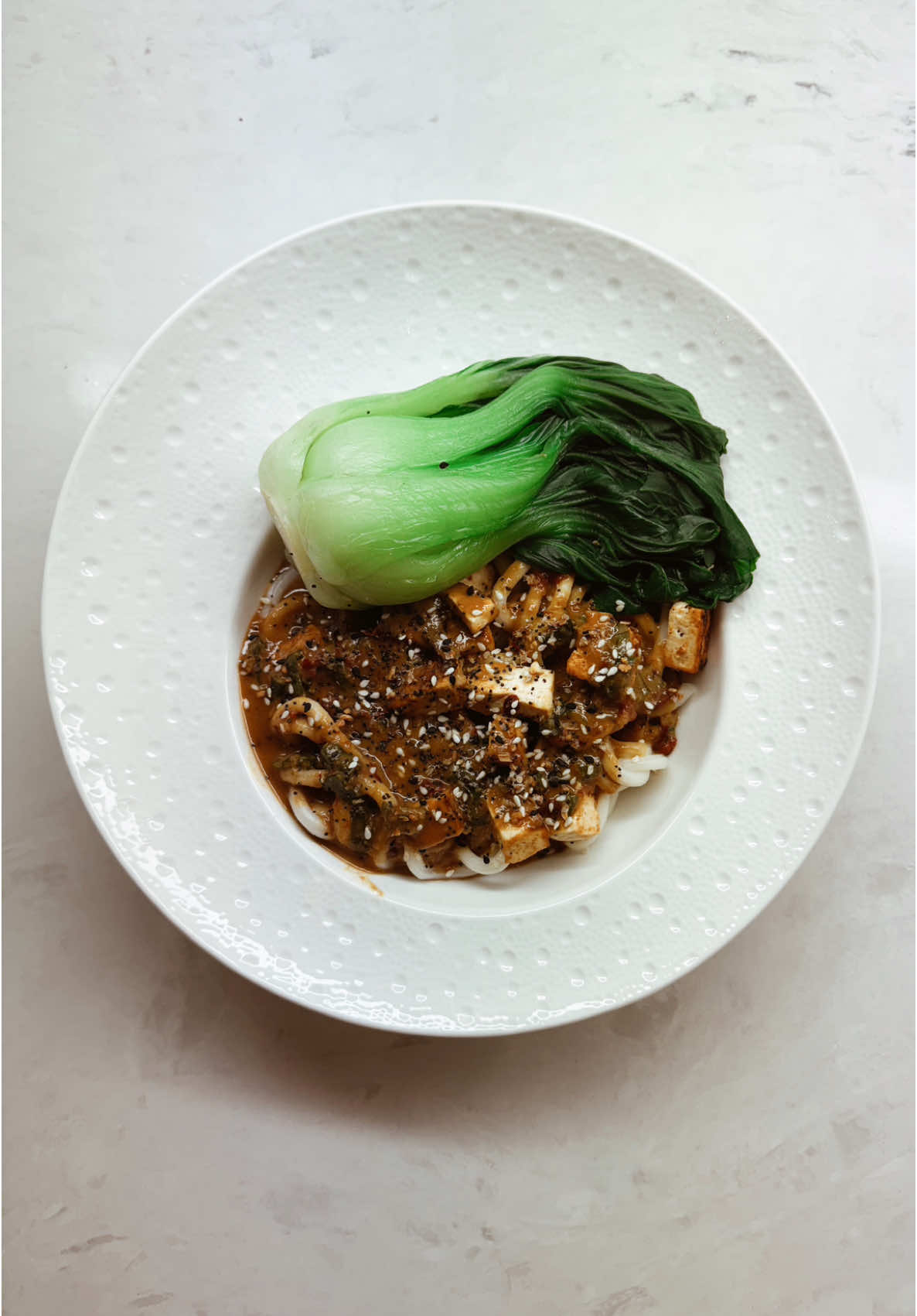 Asian inspired bok choy tofu noodle bowl with sesame seeds and deep emotional reflection