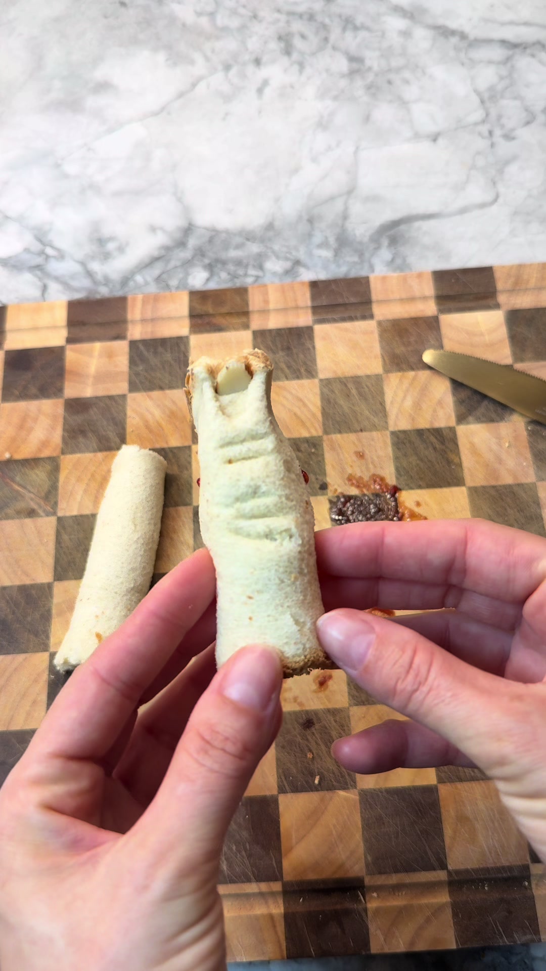 Spooky finger-shaped sandwiches with sliced almond nail details