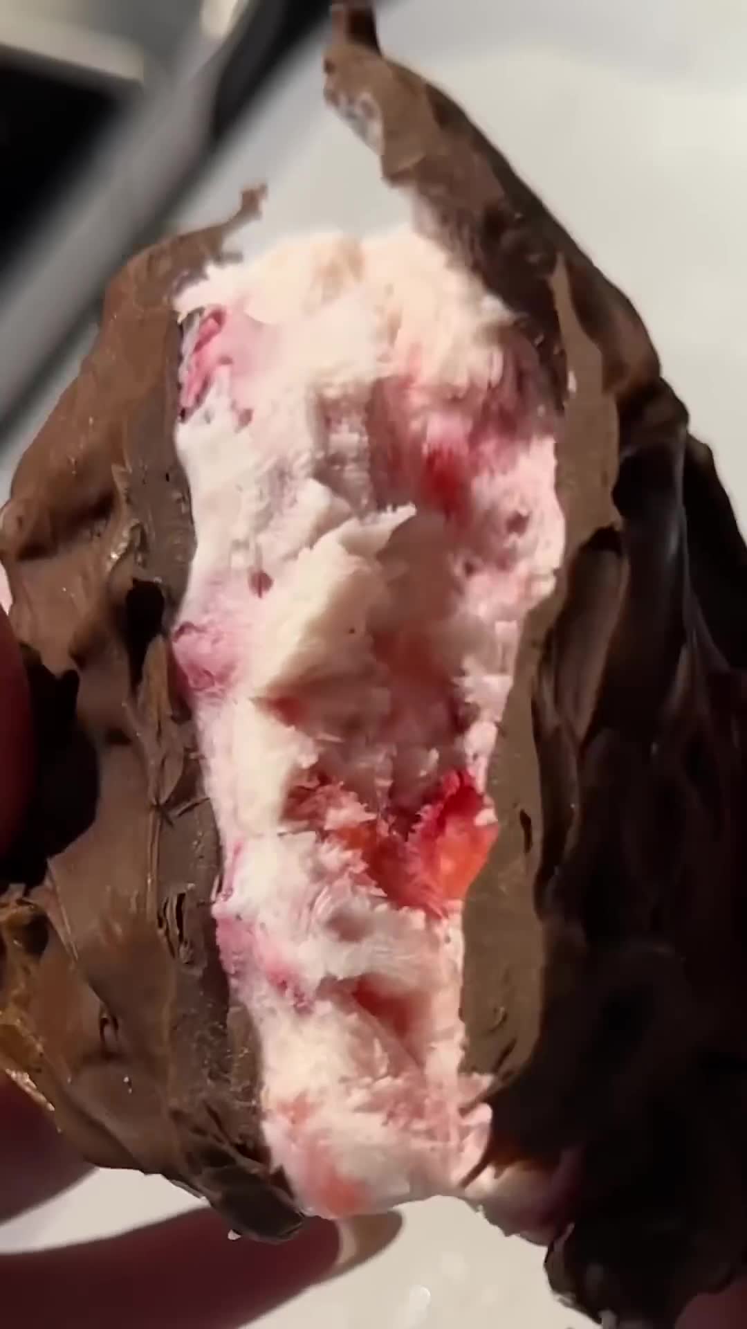Multiple strawberries grouped together under chocolate coating