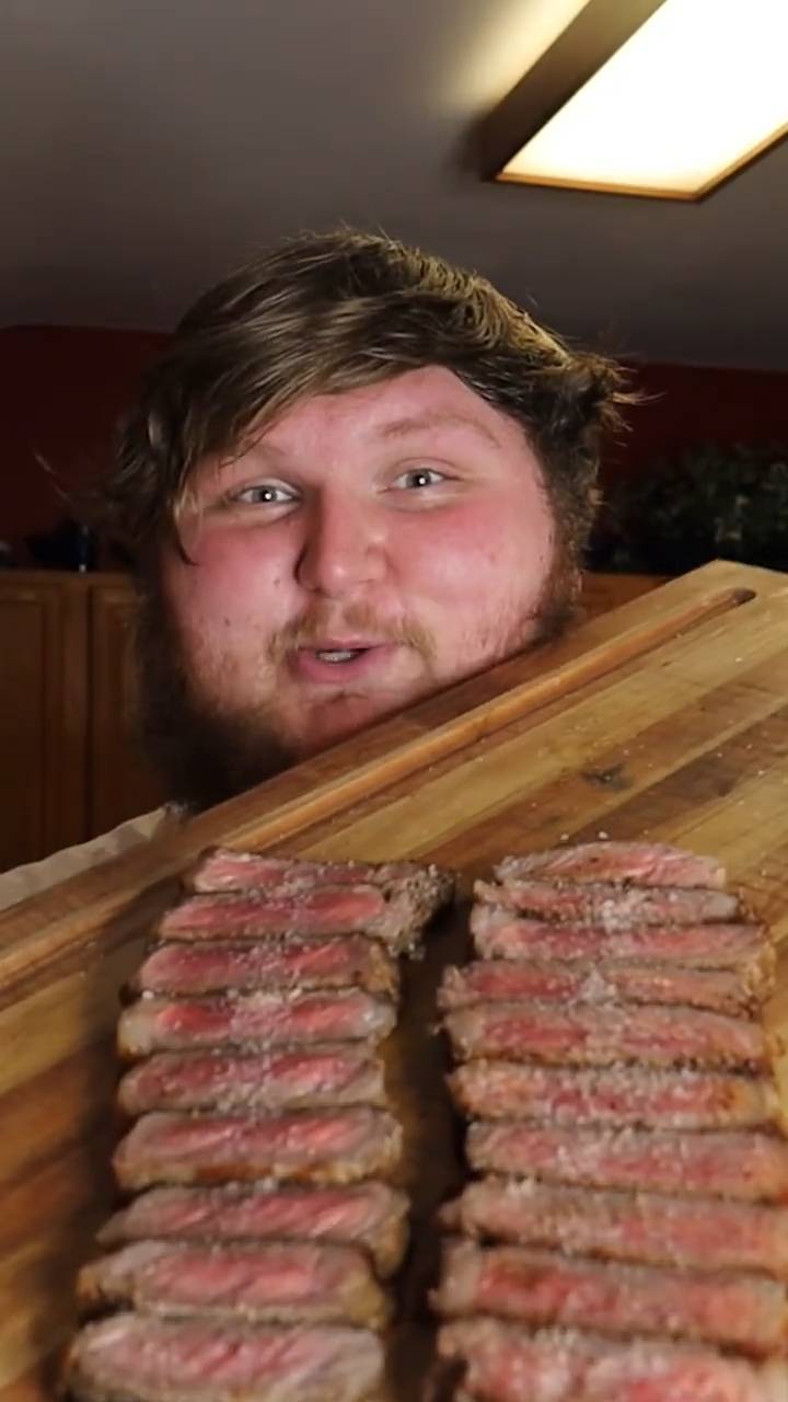 Perfectly cooked New York strip steaks with garlic compound butter