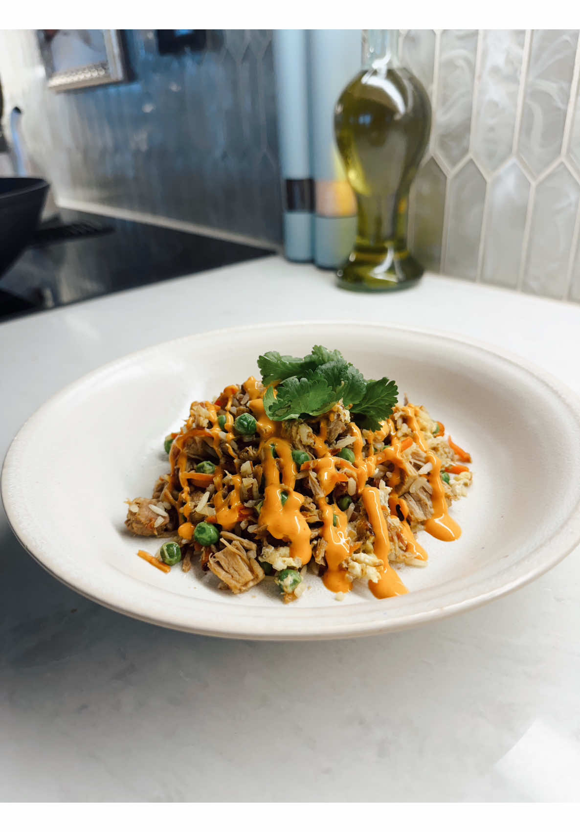 Plating homemade fried rice with shredded meat, sweet peas, carrots, and orange sauce