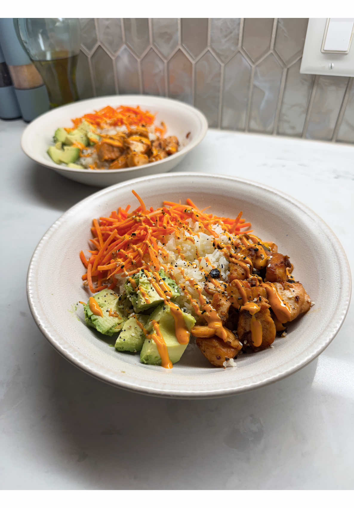Building fresh chicken avocado rice bowls topped with bright crunchy shredded carrots