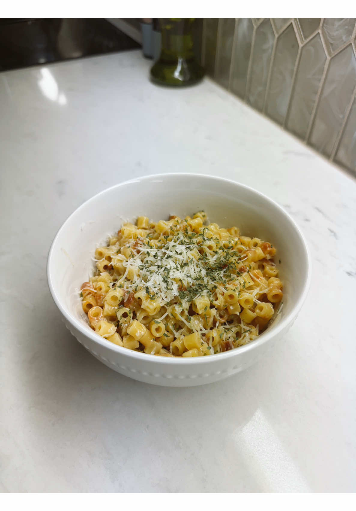 Making easy creamy ditalini pasta finished with parmesan and dried herbs for dinner