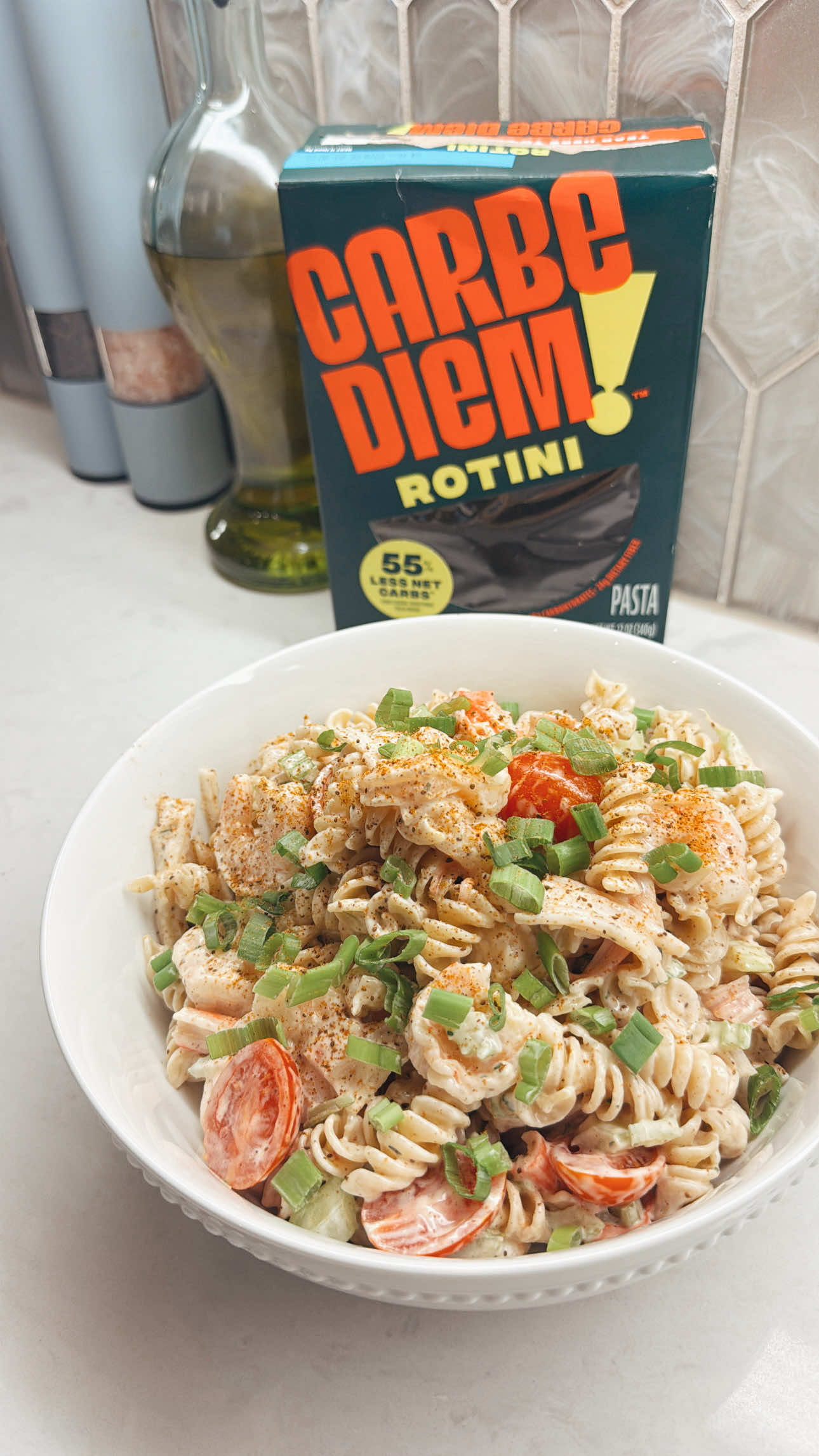 Making a Carbe Diem low carb rotini salad with plump shrimp and ripe red tomatoes