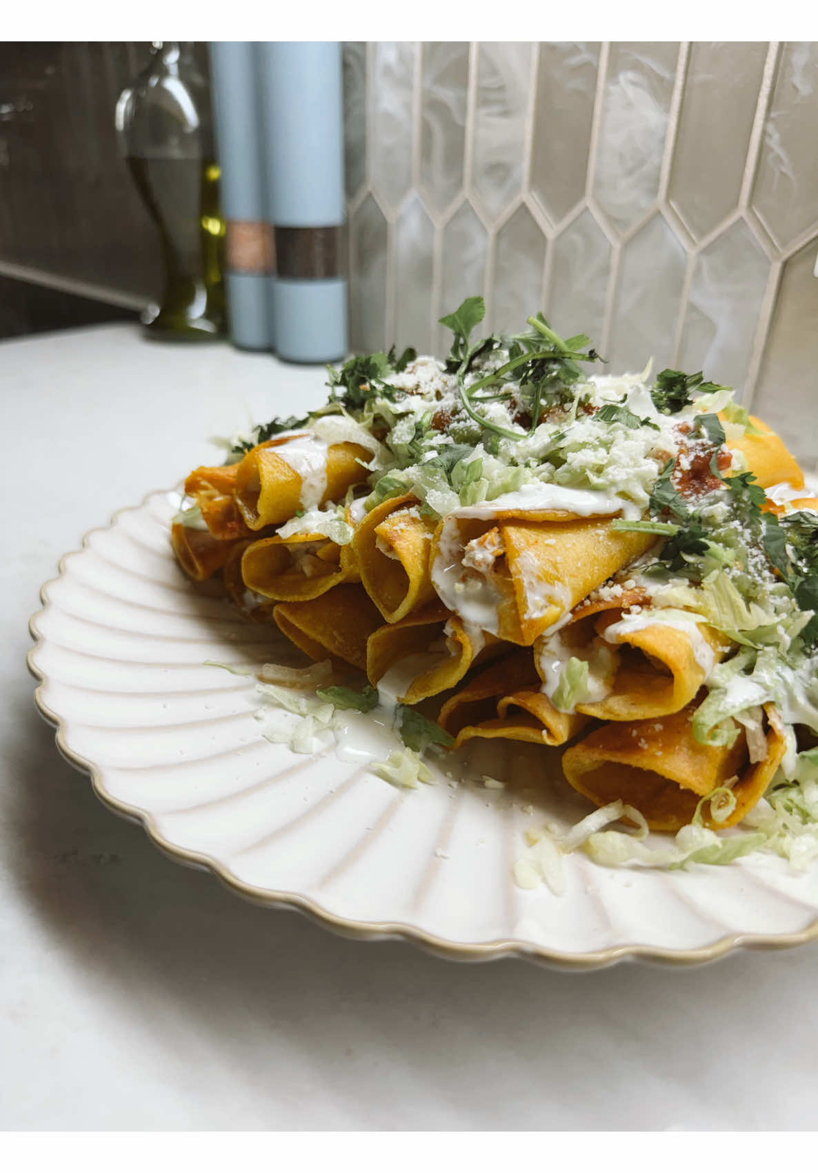 Making golden crispy taquitos at home with sour cream, fresh lettuce, and melty cheese