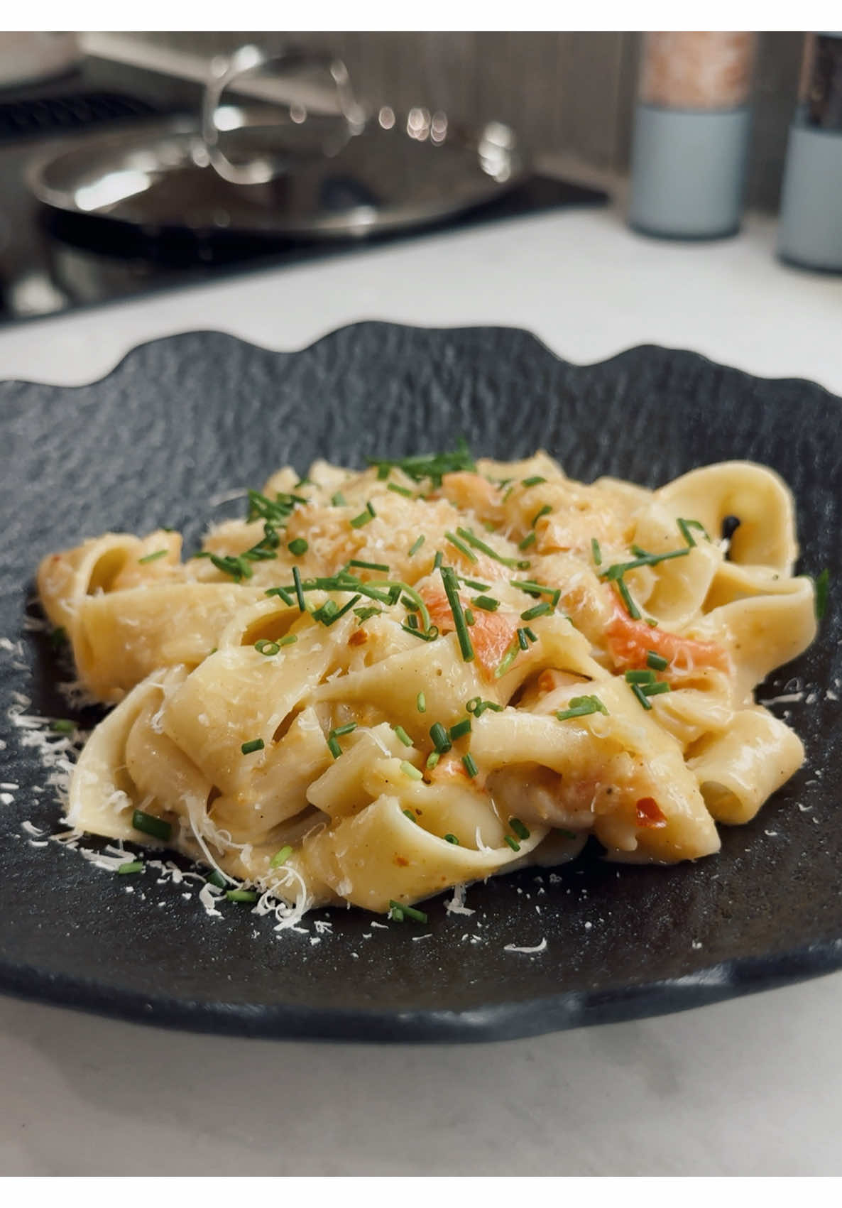Making rich creamy salmon pappardelle topped with bright chives and shaved parmesan