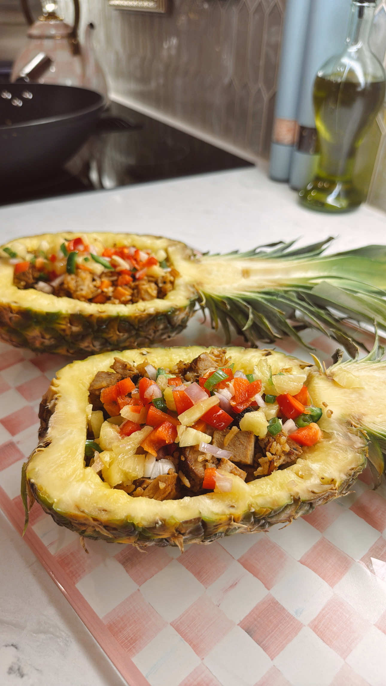 Making sweet and savory pineapple fried rice with pork and peppers in pineapple bowls