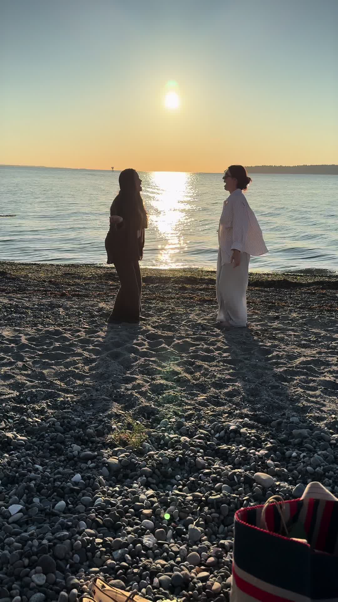 Dancing on a pebbled beach with my friend during the most beautiful golden sunset