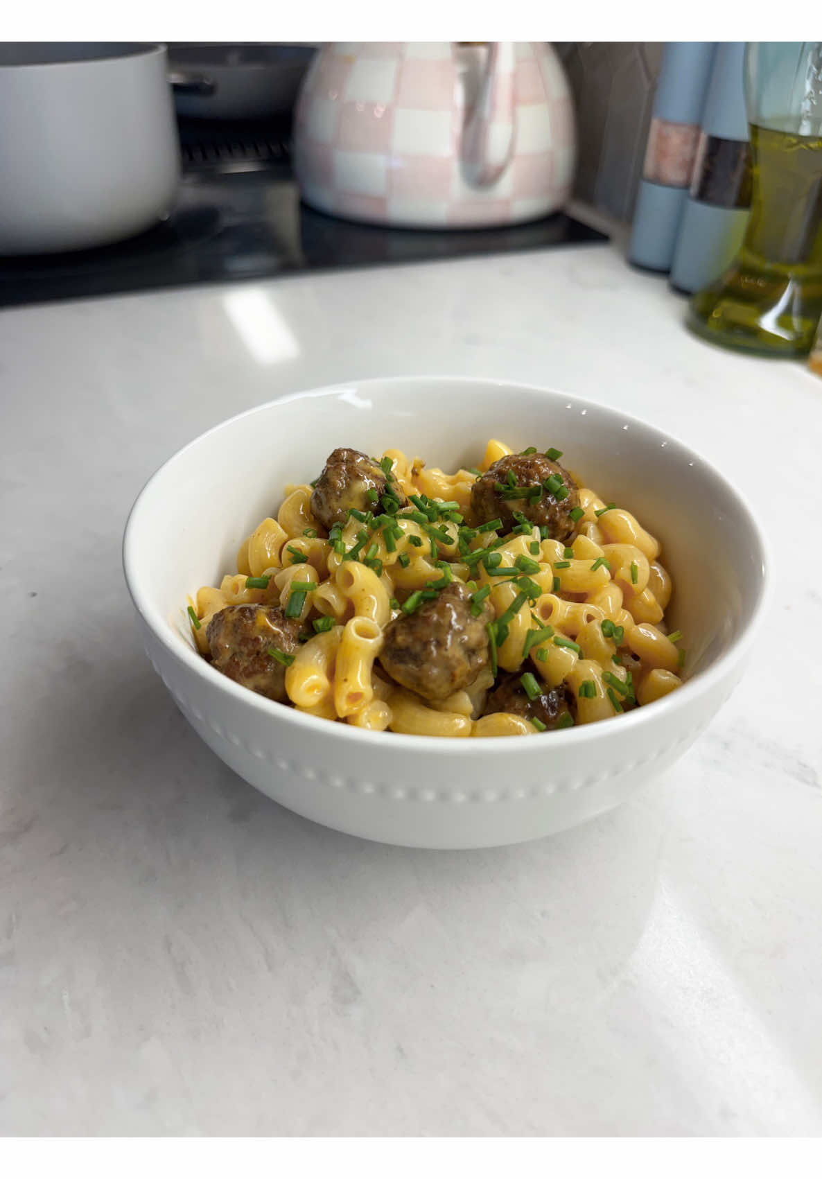 Making creamy Mimi and Eric mac and cheese with savory meatballs and bright chives